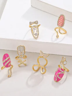 Bague de protection d'ongle ajustable dorée ornée de strass papillon et crâne rose émaillé