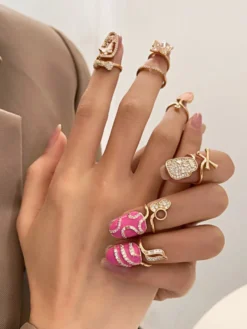 Bague de protection d'ongle ajustable dorée ornée de strass papillon et crâne rose émaillé