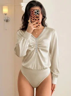 Body en satin champagne à manches longues col V orné de strass froncé sur le devant manches bouffantes coupe ajustée