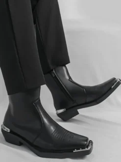 Bottines noires à bout carré et talon épais ornées de détails métalliques