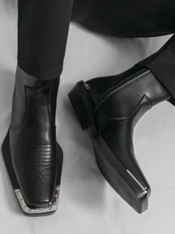 Bottines noires à bout carré et talon épais ornées de détails métalliques