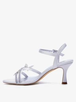 Chaussures de mariage en satin à bout ouvert ornées de strass et d'un détail papillon à talons hauts.