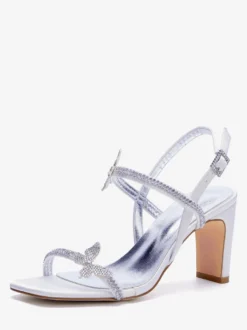Chaussures de mariée blanches à talons compensés ornées de strass et de papillons bout ouvert.