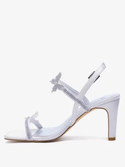Chaussures de mariée blanches à talons compensés ornées de strass et de papillons bout ouvert.