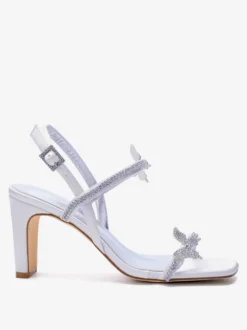 Chaussures de mariée blanches à talons compensés ornées de strass et de papillons bout ouvert.