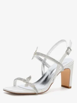 Chaussures de mariée blanches à talons compensés ornées de strass et de papillons bout ouvert.