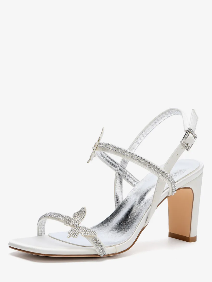Chaussures de mariée blanches à talons compensés ornées de strass et de papillons bout ouvert.