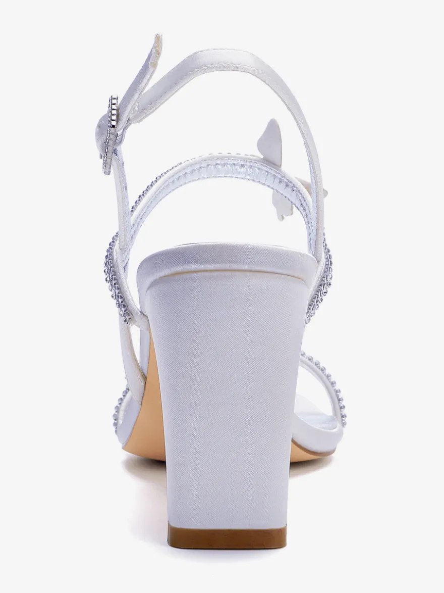 Chaussures de mariée blanches à talons compensés ornées de strass et de papillons bout ouvert.