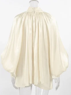Chemisier oversize en satin crème brillant à col montant froncé manches ballon et poignets perlés