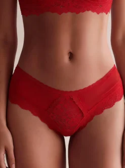 Culotte femme en maille transparente avec découpes et bretelles apparentes.