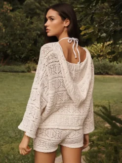 Ensemble deux pièces en crochet ajouré pour femme : haut court à manches longues évasées et col en V short taille haute et paréo.