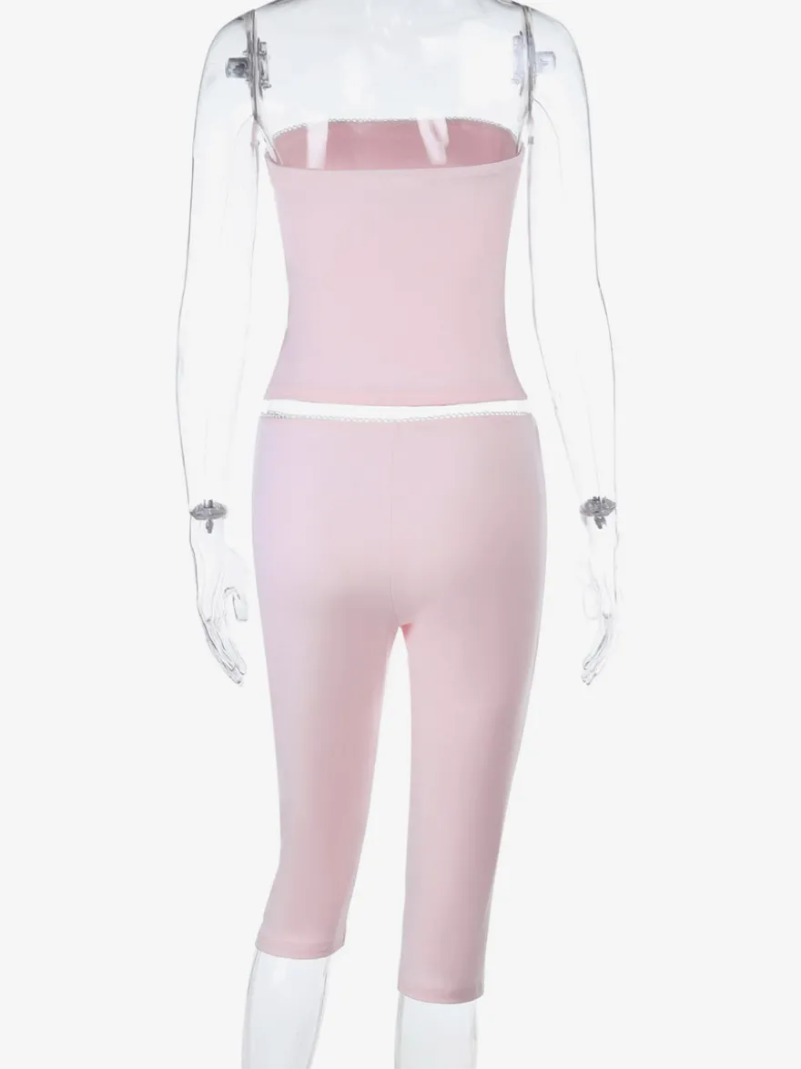 Ensemble deux pièces rose en dentelle : haut bustier sans bretelles legging capri taille haute et bordure en dentelle.