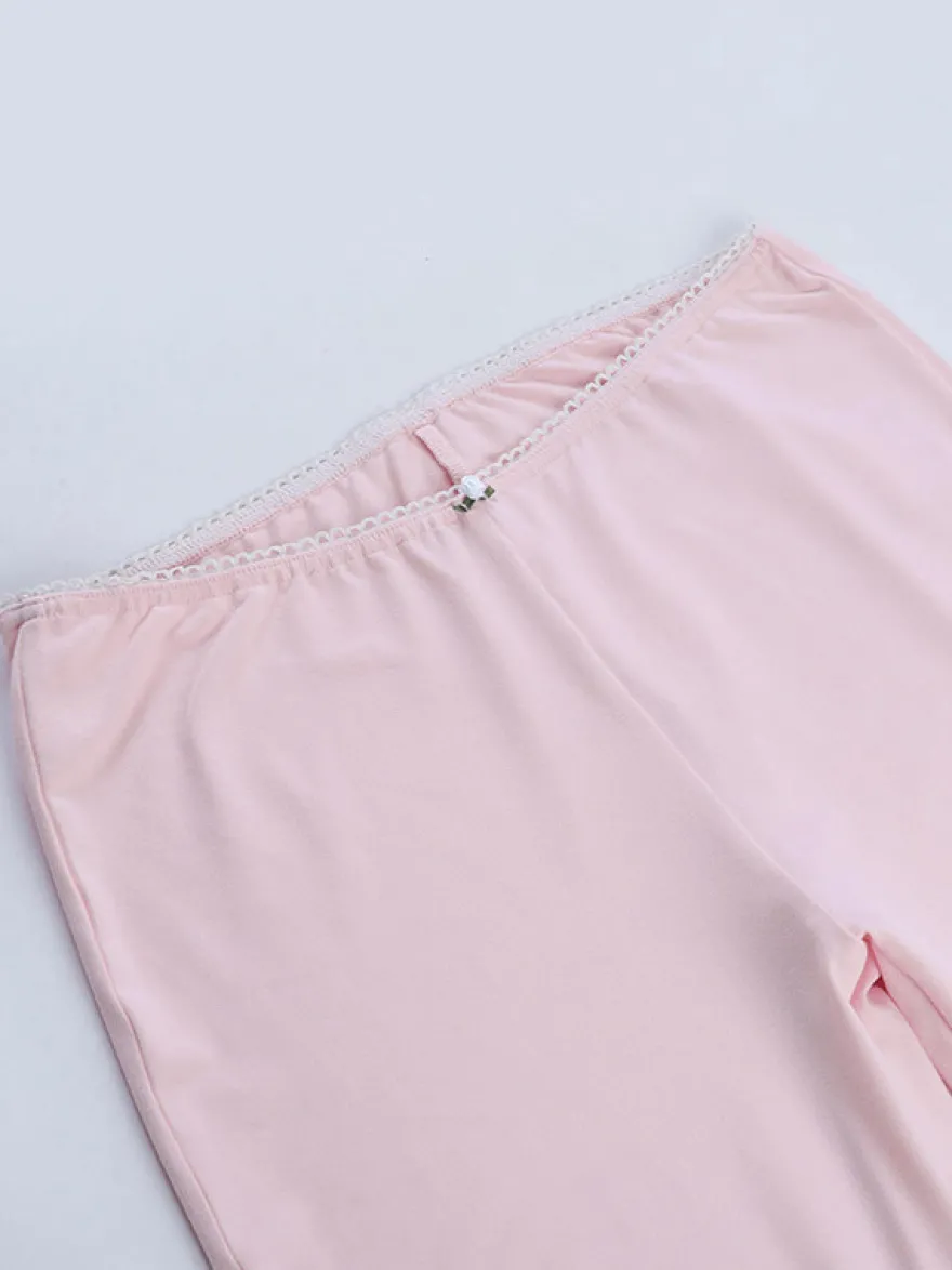 Ensemble deux pièces rose en dentelle : haut bustier sans bretelles legging capri taille haute et bordure en dentelle.