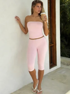 Ensemble deux pièces rose en dentelle : haut bustier sans bretelles legging capri taille haute et bordure en dentelle.