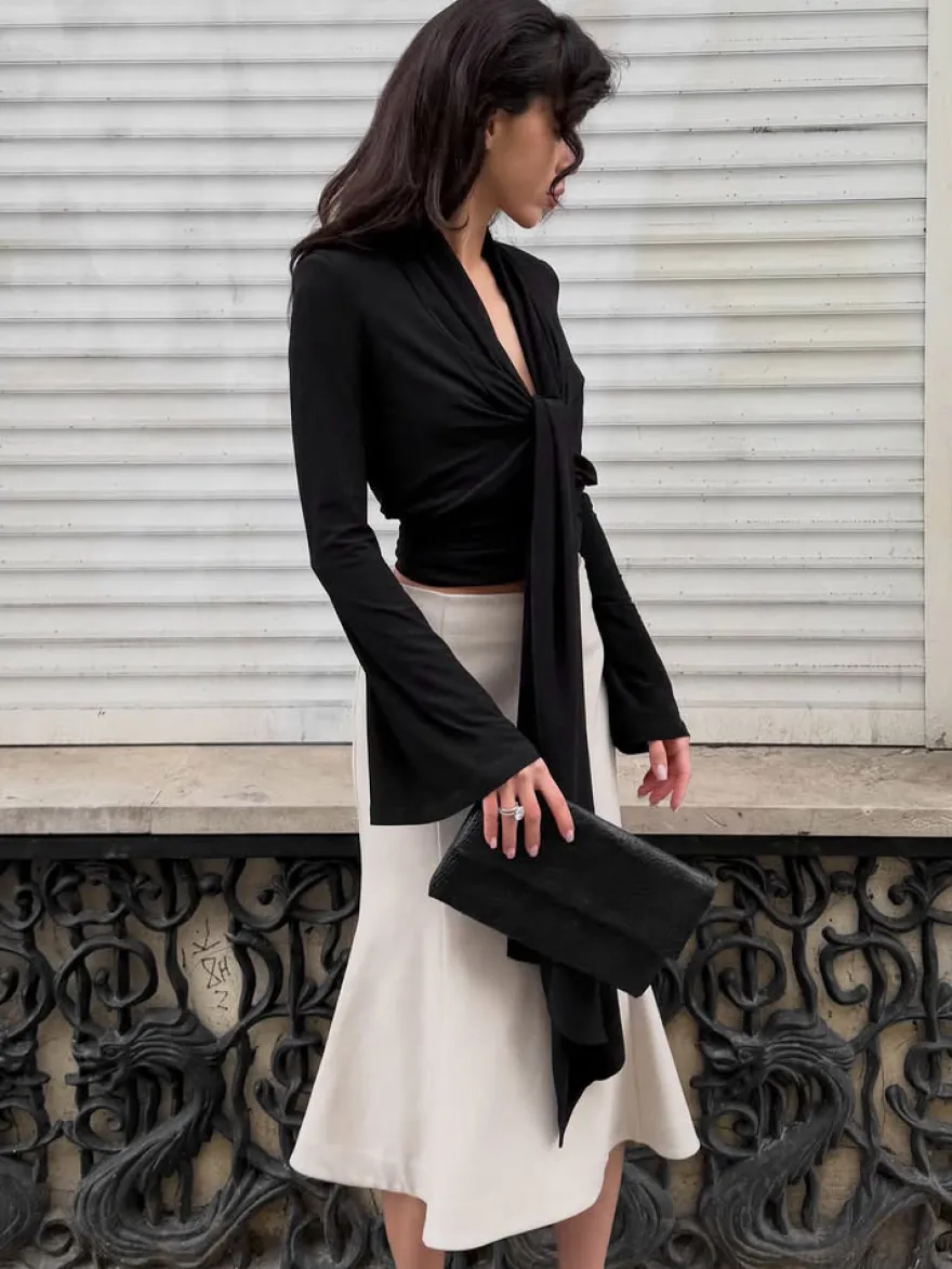 Haut court à nouer sur le devant et décolleté en V profond froncé blouse cintrée à manches longues et coupe évasée.