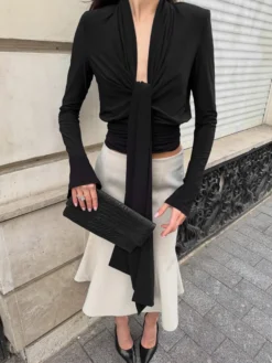 Haut court à nouer sur le devant et décolleté en V profond froncé blouse cintrée à manches longues et coupe évasée.