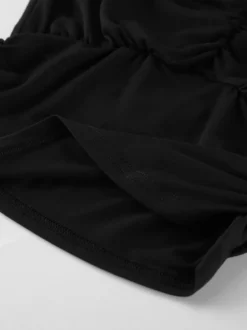 Haut court à nouer sur le devant et décolleté en V profond froncé blouse cintrée à manches longues et coupe évasée.