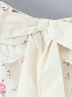 Mini-robe fleurie à épaules dénudées et nœud pour l'été 2026