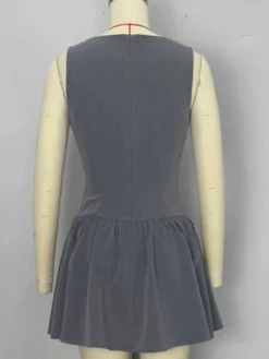 Mini-robe plissée sans manches et boutonnée sur le devant grise été 2026