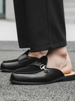 Mocassins noirs à bout rond avec détails métalliques et talon ouvert