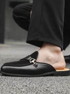 Mocassins noirs à bout rond avec détails métalliques et talon ouvert