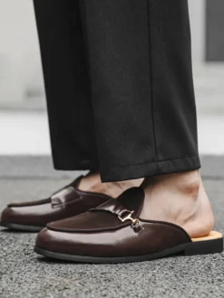 Mocassins noirs à bout rond avec détails métalliques et talon ouvert