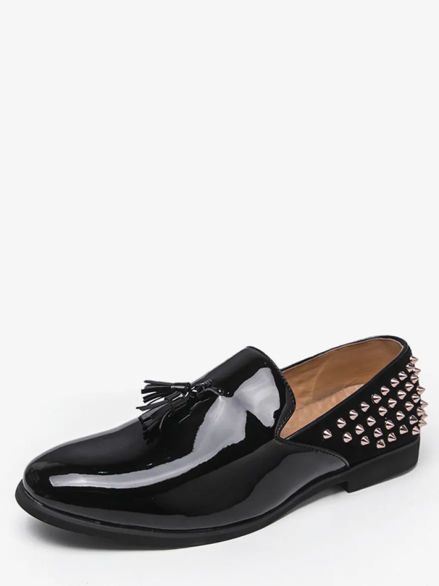Mocassins noirs à bout rond pour homme ornés de rivets et de pompons.