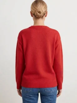 Pull femme à col rond en maille brodée de poissons manches longues coupe ample et décontractée.