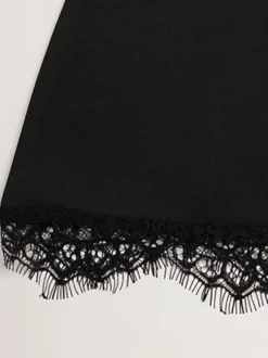 Robe courte élégante noire à col montant et manches courtes coupe trapèze ornée de dentelle et à découpe en forme de goutte - Idéale pour une fête d'anniversaire printanière (2026)