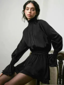Robe courte noire en satin à volants et col montant manches bouffantes col montant et taille haute idéale pour tous les jours.