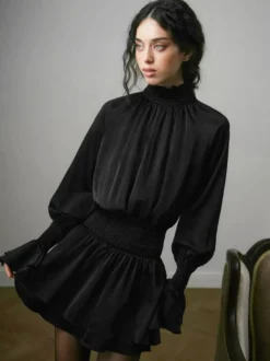 Robe courte noire en satin à volants et col montant manches bouffantes col montant et taille haute idéale pour tous les jours.