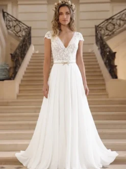 Robe de mariée bohème en dentelle et mousseline coupe trapèze taille naturelle fermeture éclair manches courtes col en V idéale pour un mariage à la mairie.