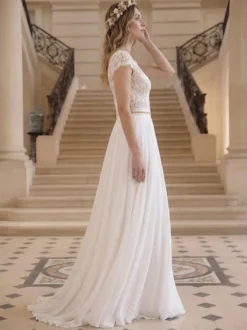 Robe de mariée bohème en dentelle et mousseline coupe trapèze taille naturelle fermeture éclair manches courtes col en V idéale pour un mariage à la mairie.