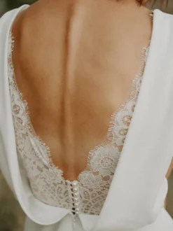 Robe de mariée bohème en dentelle coupe trapèze avec traîne taille naturelle fermeture éclair sans manches col en V blanche