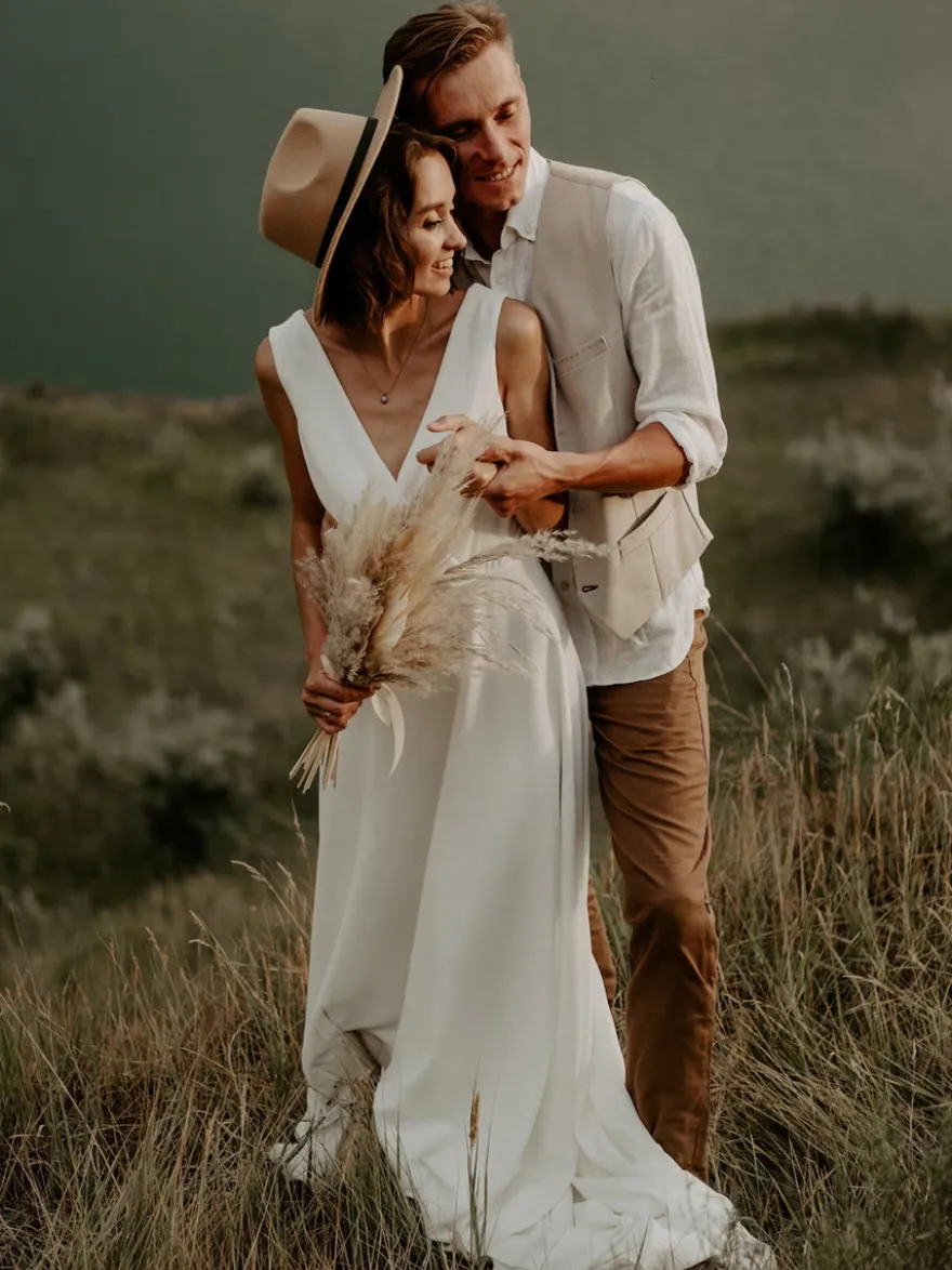 Robe de mariée bohème en dentelle coupe trapèze avec traîne taille naturelle fermeture éclair sans manches col en V blanche