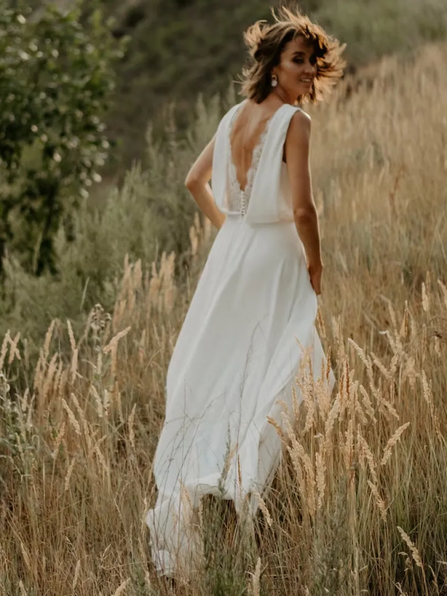Robe de mariée bohème en dentelle coupe trapèze avec traîne taille naturelle fermeture éclair sans manches col en V blanche