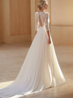 Robe de mariée bohème en mousseline découpée coupe trapèze avec traîne taille naturelle dos nu manches 3/4 col carré couleur ivoire