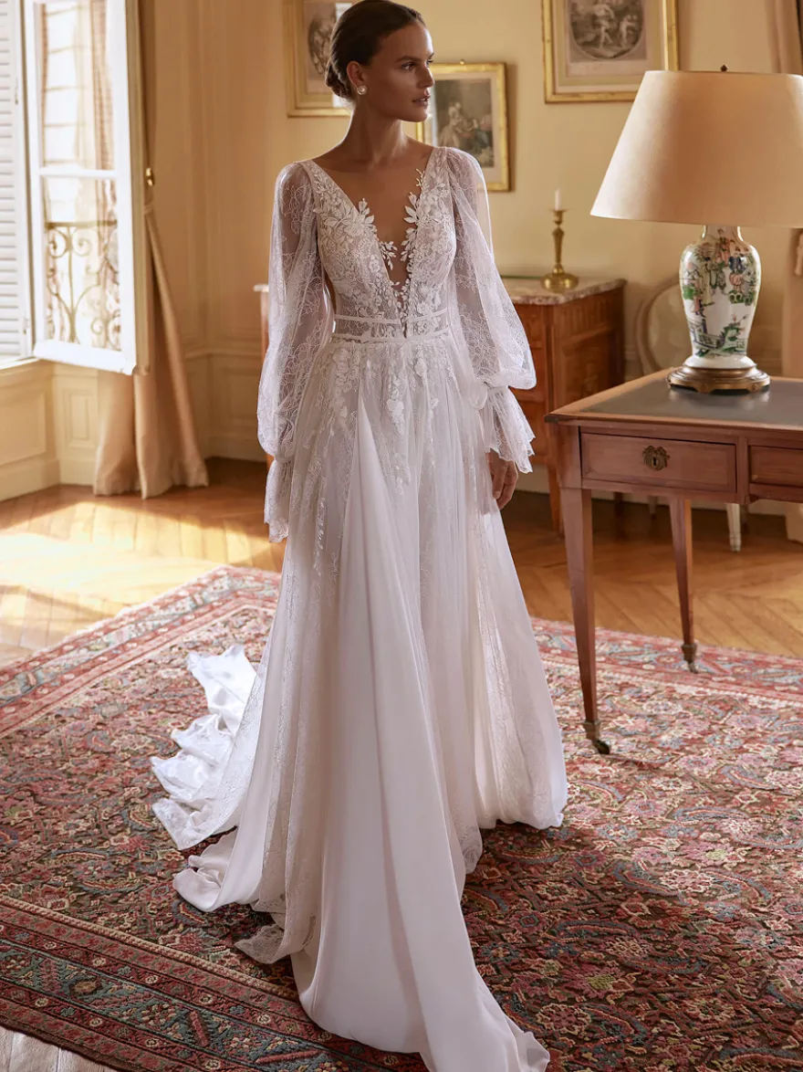 Robe de mariée bohème en mousseline et dentelle coupe trapèze avec traîne taille naturelle fermeture éclair manches longues col en V blanche