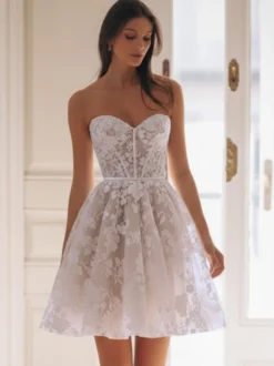 Robe de mariée courte en tulle décolleté en cœur manches 3/4 taille naturelle.