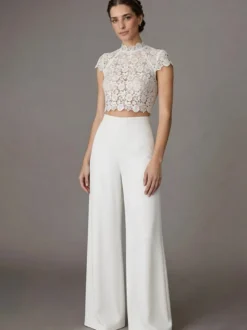 Robe de mariée deux pièces en crêpe stretch décolleté travaillé longueur au sol fermeture éclair manches courtes.