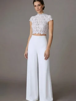 Robe de mariée deux pièces en crêpe stretch décolleté travaillé longueur au sol fermeture éclair manches courtes.