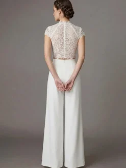 Robe de mariée deux pièces en crêpe stretch décolleté travaillé longueur au sol fermeture éclair manches courtes.