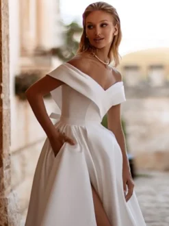Robe de mariée vintage avec traîne épaules dénudées manches courtes fente sur le devant en satin.