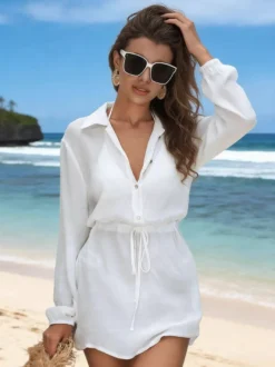 Robe de vacances blanche chic à boutons cintrants manches longues et col rabattu.