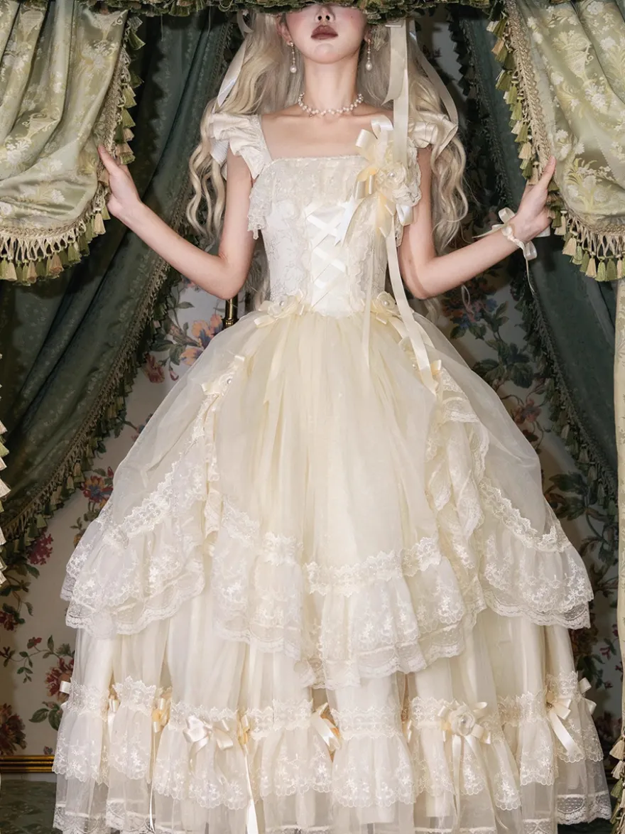 Robe longue Lolita fée blanche à lacets et nœuds ornée de fleurs idéale pour un goûter.