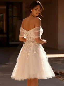 Robes de mariée courtes décolleté travaillé manches courtes coupe trapèze