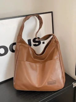Sac bandoulière hobo minimaliste en similicuir souple grand format en forme de U à porter sous l'aisselle.