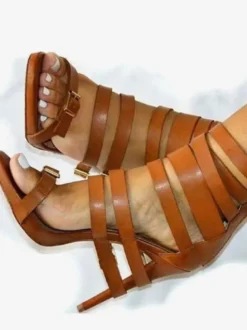 Sandales gladiateur noires à talons hauts et bout ouvert ornées d'une boucle.