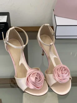 Sandales noires de soirée en satin à bout ouvert et détails floraux en forme de T à talons hauts.