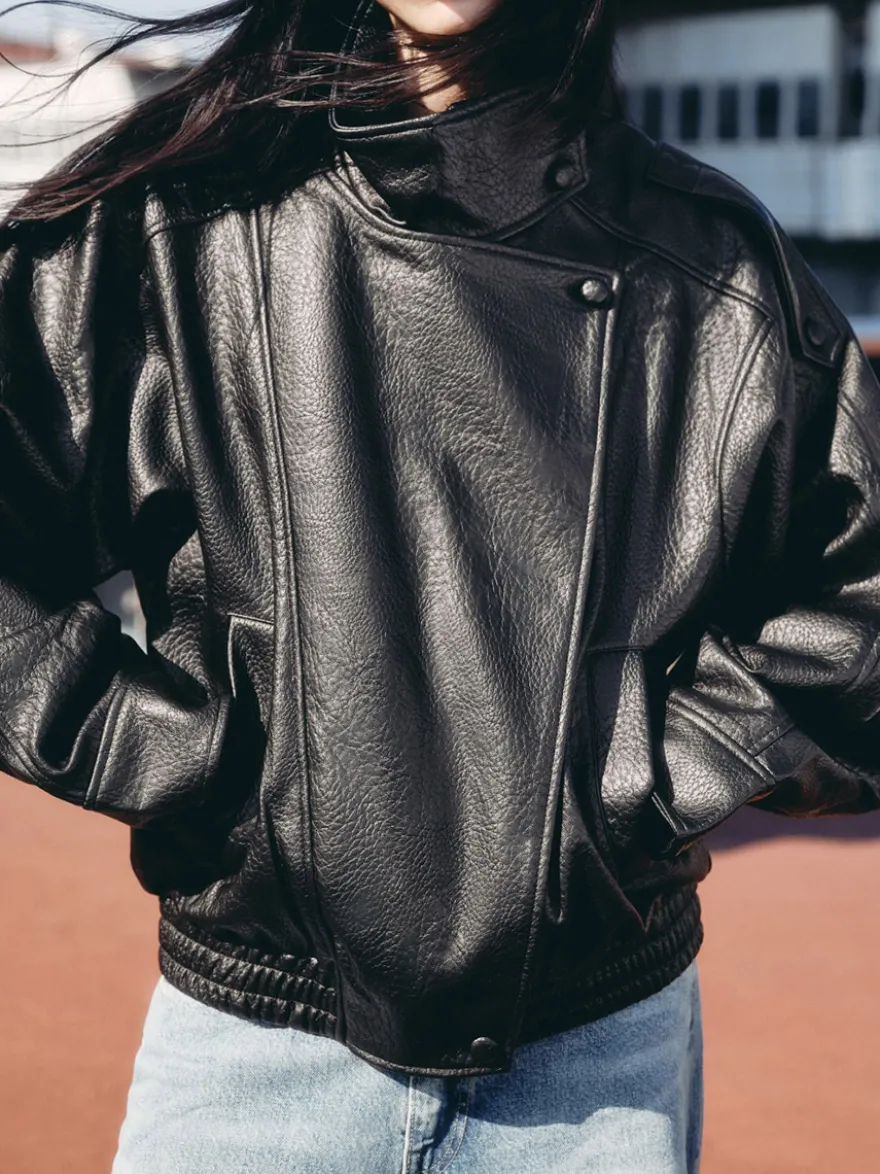 Veste bomber vintage en similicuir noir et marron uni coupe décontractée taille élastiquée.